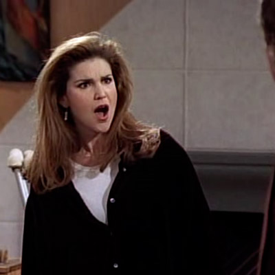 Roz is looking at Frazier, with a surprised and hateful facial expression.