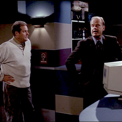 Frasier is trying to collect his lost suitcase and is standing waiting for the clerk to return to the desk.